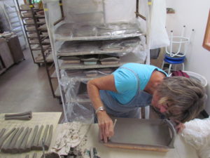 Michele Ebert working on trays in the Clay Coyote Pottery Studio